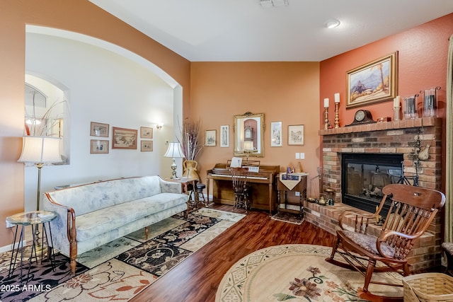 living room featuring a brick fireplace and hardwood / wood-style floors