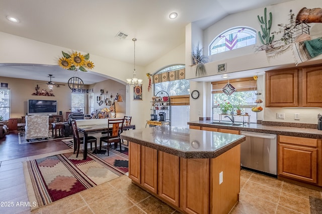 kitchen with sink, a kitchen island, vaulted ceiling, and dishwasher