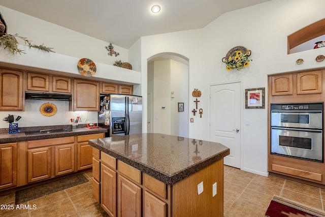 kitchen featuring a kitchen island, high vaulted ceiling, and appliances with stainless steel finishes