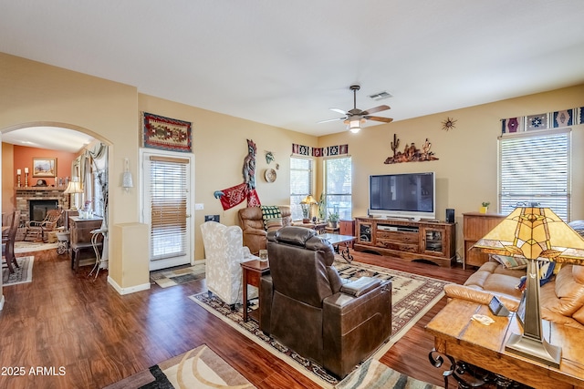 living room featuring a fireplace, ceiling fan, and dark hardwood / wood-style floors