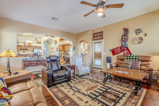 living room featuring ceiling fan with notable chandelier and wood-type flooring