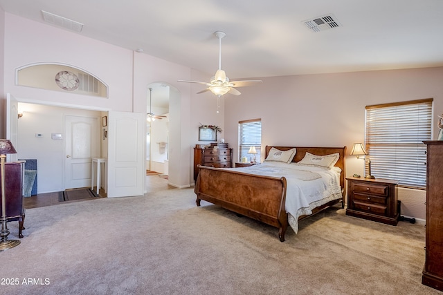 carpeted bedroom with ceiling fan and high vaulted ceiling