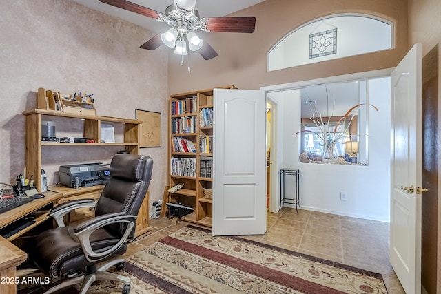 office featuring a high ceiling, ceiling fan, and light tile patterned floors