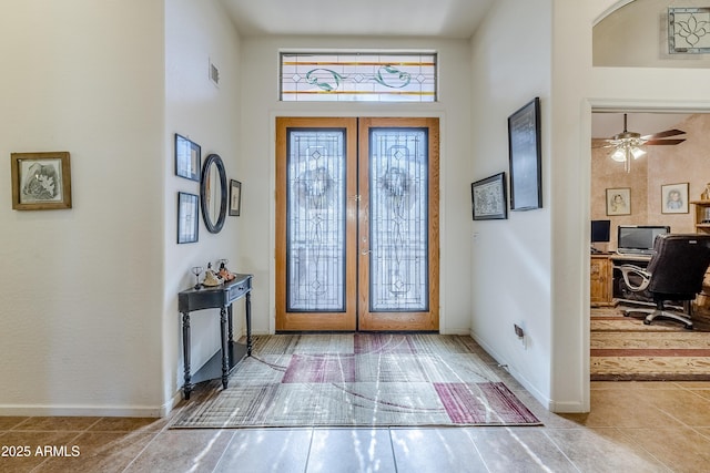 entrance foyer with a high ceiling, ceiling fan, and french doors