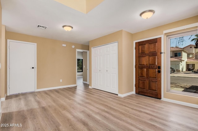 foyer featuring light wood finished floors, visible vents, and baseboards