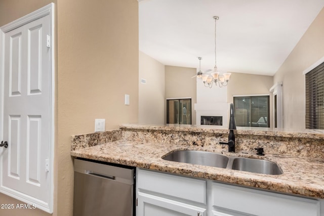 kitchen with dishwasher, lofted ceiling, an inviting chandelier, white cabinetry, and a sink