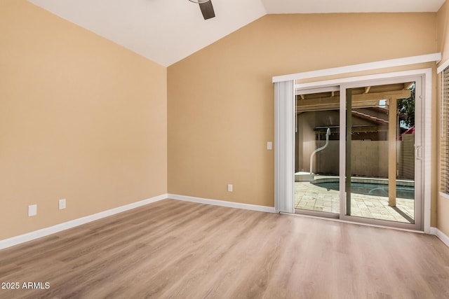 empty room with wood finished floors, baseboards, and vaulted ceiling