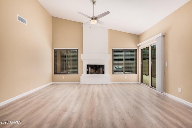 unfurnished living room featuring lofted ceiling, baseboards, visible vents, and a large fireplace