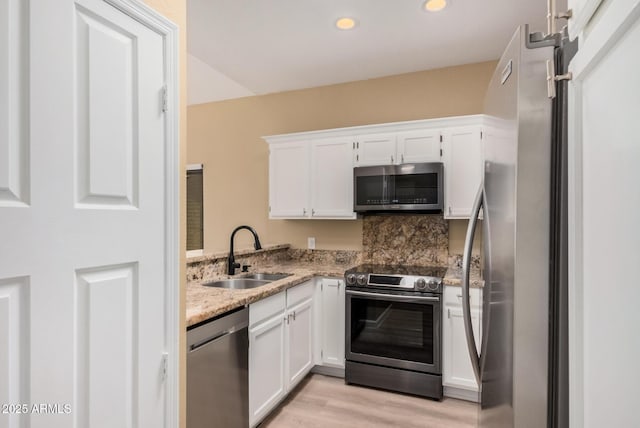 kitchen featuring a sink, white cabinetry, recessed lighting, light wood-style floors, and appliances with stainless steel finishes