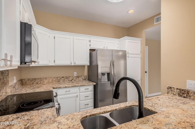 kitchen with visible vents, stainless steel fridge with ice dispenser, white cabinetry, black / electric stove, and a sink