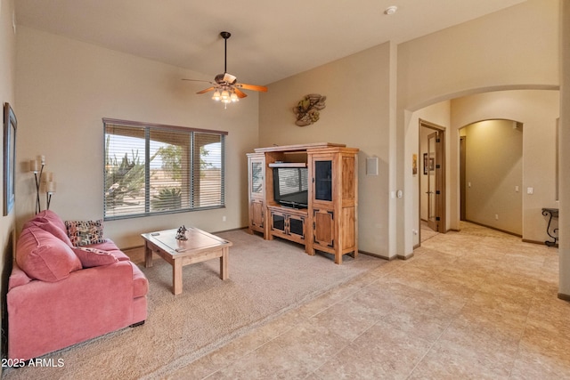 living room featuring ceiling fan, vaulted ceiling, and light carpet