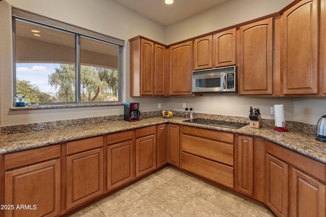 kitchen featuring black electric cooktop and stone counters