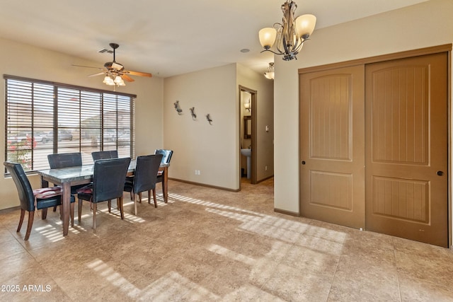 dining space with ceiling fan with notable chandelier