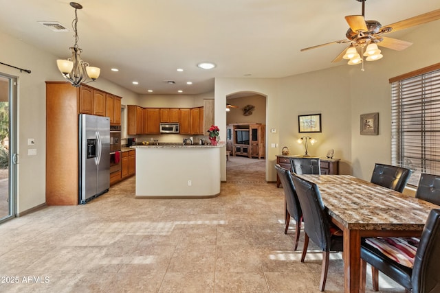 kitchen featuring stainless steel appliances, decorative light fixtures, and ceiling fan with notable chandelier