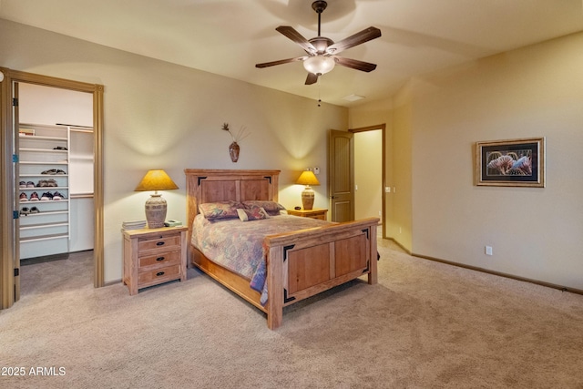 carpeted bedroom featuring a spacious closet, ceiling fan, and a closet