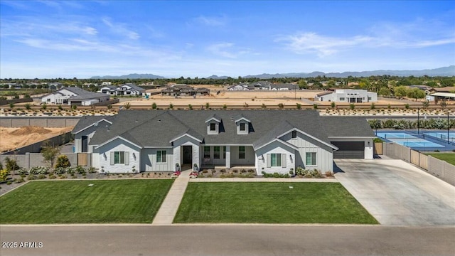 view of front of house featuring concrete driveway, board and batten siding, a garage, a mountain view, and a residential view