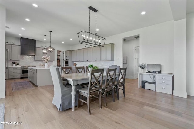 dining area featuring recessed lighting, light wood finished floors, and a chandelier