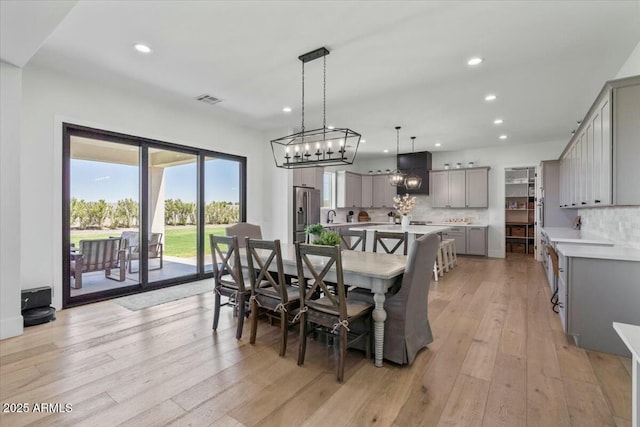 dining area featuring recessed lighting, light wood-type flooring, and a chandelier