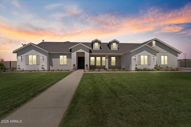 view of front of house with board and batten siding and a lawn