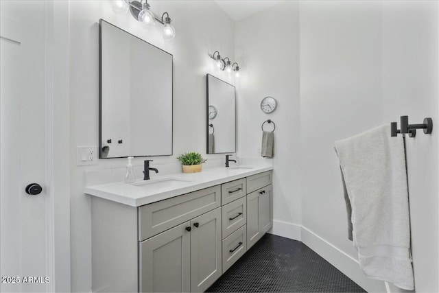 bathroom with double vanity, baseboards, and tile patterned flooring