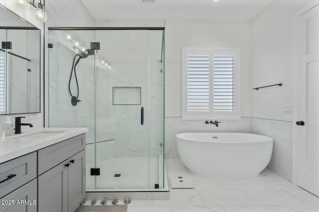 bathroom featuring a marble finish shower, vanity, a freestanding tub, and marble finish floors