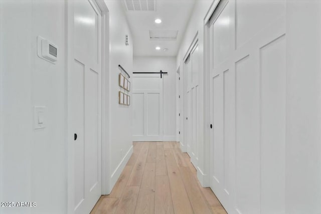 hall with light wood-type flooring, recessed lighting, and baseboards