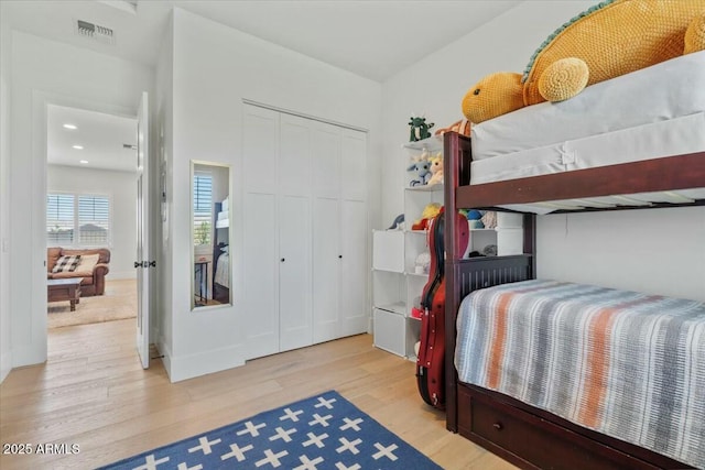 bedroom with wood finished floors and a closet