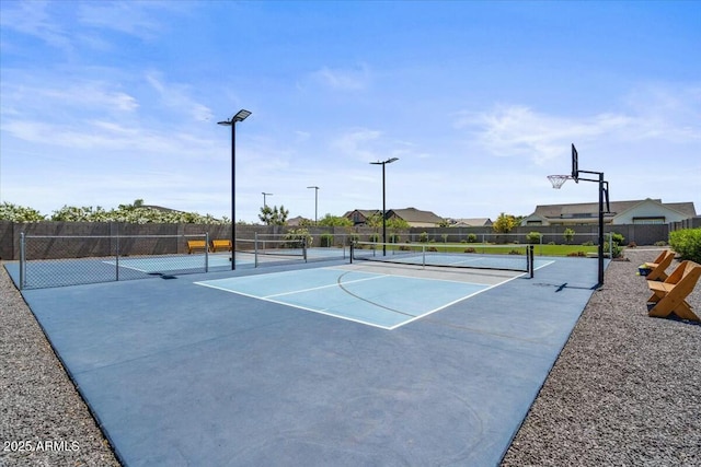 view of sport court featuring a tennis court and fence
