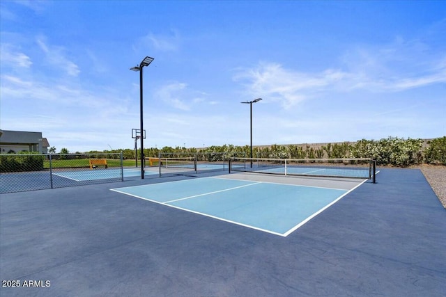 view of tennis court with fence and community basketball court