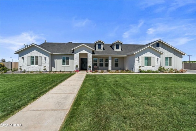view of front of house with board and batten siding, a front yard, and stone siding