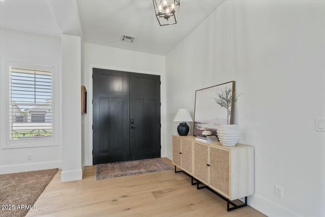 entryway with baseboards and light wood finished floors