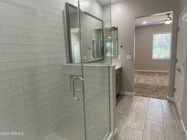 bathroom featuring vanity, ceiling fan, and a shower with door