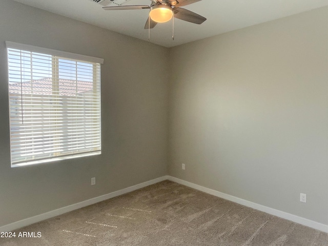 carpeted spare room featuring ceiling fan