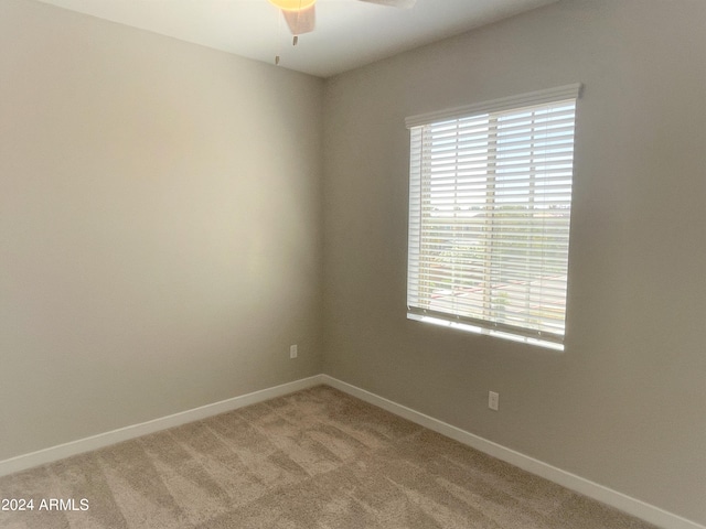 empty room featuring light colored carpet and ceiling fan