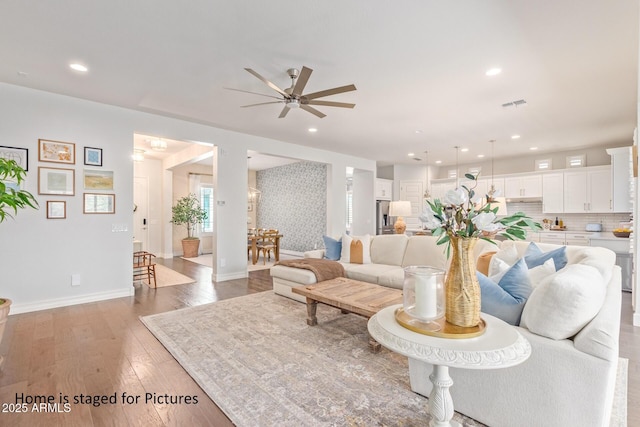 living room with hardwood / wood-style flooring and ceiling fan