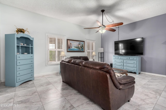 living room with a textured ceiling and ceiling fan