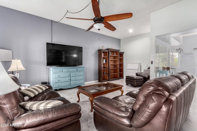 living room with ceiling fan and a textured ceiling