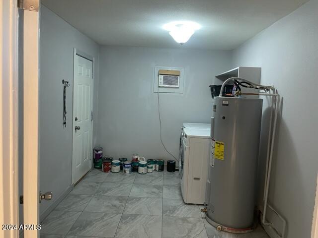 clothes washing area featuring separate washer and dryer and electric water heater