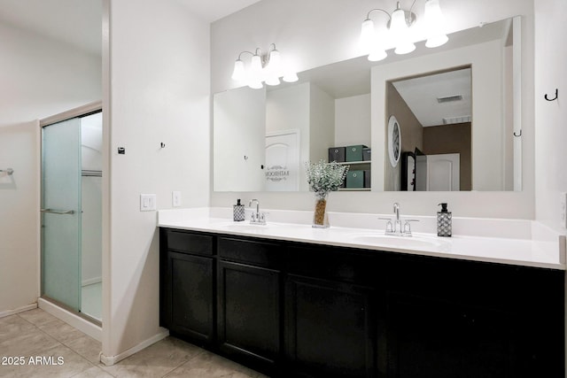 30777 W Whitton Ave, Buckeye, AZ 85396 - bathroom featuring double vanity, tile patterned flooring, a shower with door, and baseboards