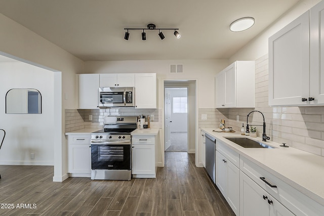 1616 E Pecan Rd, Phoenix, AZ 85040 - kitchen featuring appliances with stainless steel finishes, white cabinetry, dark wood-type flooring, light countertops, and decorative backsplash