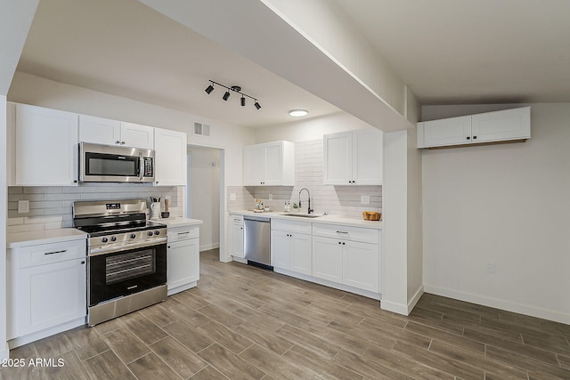 1616 E Pecan Rd, Phoenix, AZ 85040 - kitchen with stainless steel appliances, white cabinetry, light countertops, tasteful backsplash, and wood finished floors