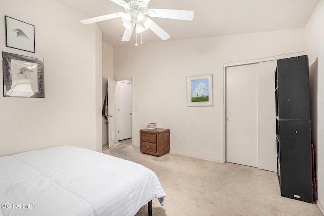 bedroom with ceiling fan, a closet, and light carpet