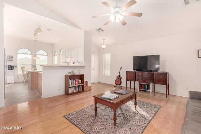 living room featuring ceiling fan, light hardwood / wood-style flooring, and vaulted ceiling