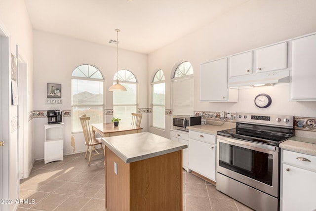 kitchen with appliances with stainless steel finishes, a healthy amount of sunlight, pendant lighting, white cabinets, and a kitchen island