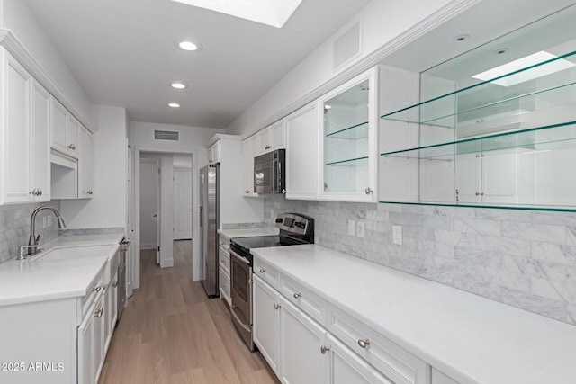 kitchen featuring a sink, visible vents, white cabinetry, and stainless steel appliances