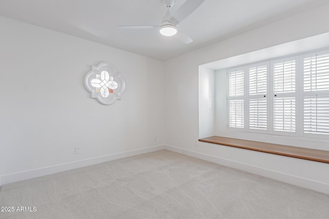 empty room featuring ceiling fan, baseboards, and light carpet