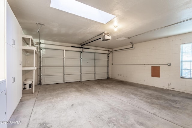 garage with a garage door opener and concrete block wall