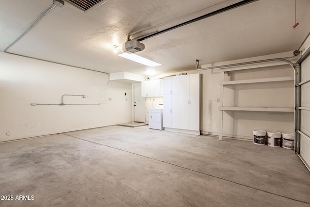 garage featuring visible vents, washer / clothes dryer, and a garage door opener