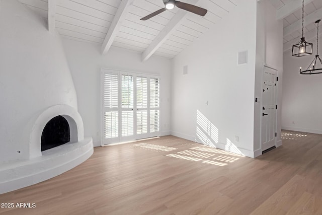 unfurnished living room featuring visible vents, baseboards, beamed ceiling, ceiling fan with notable chandelier, and wood finished floors