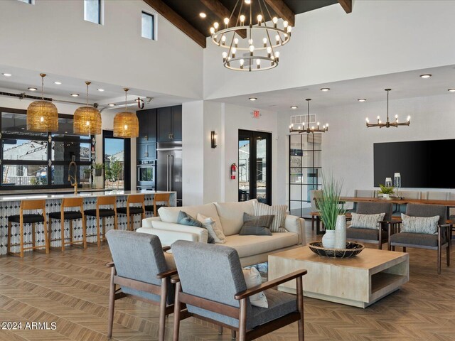 living room with parquet floors, beamed ceiling, a chandelier, and a high ceiling